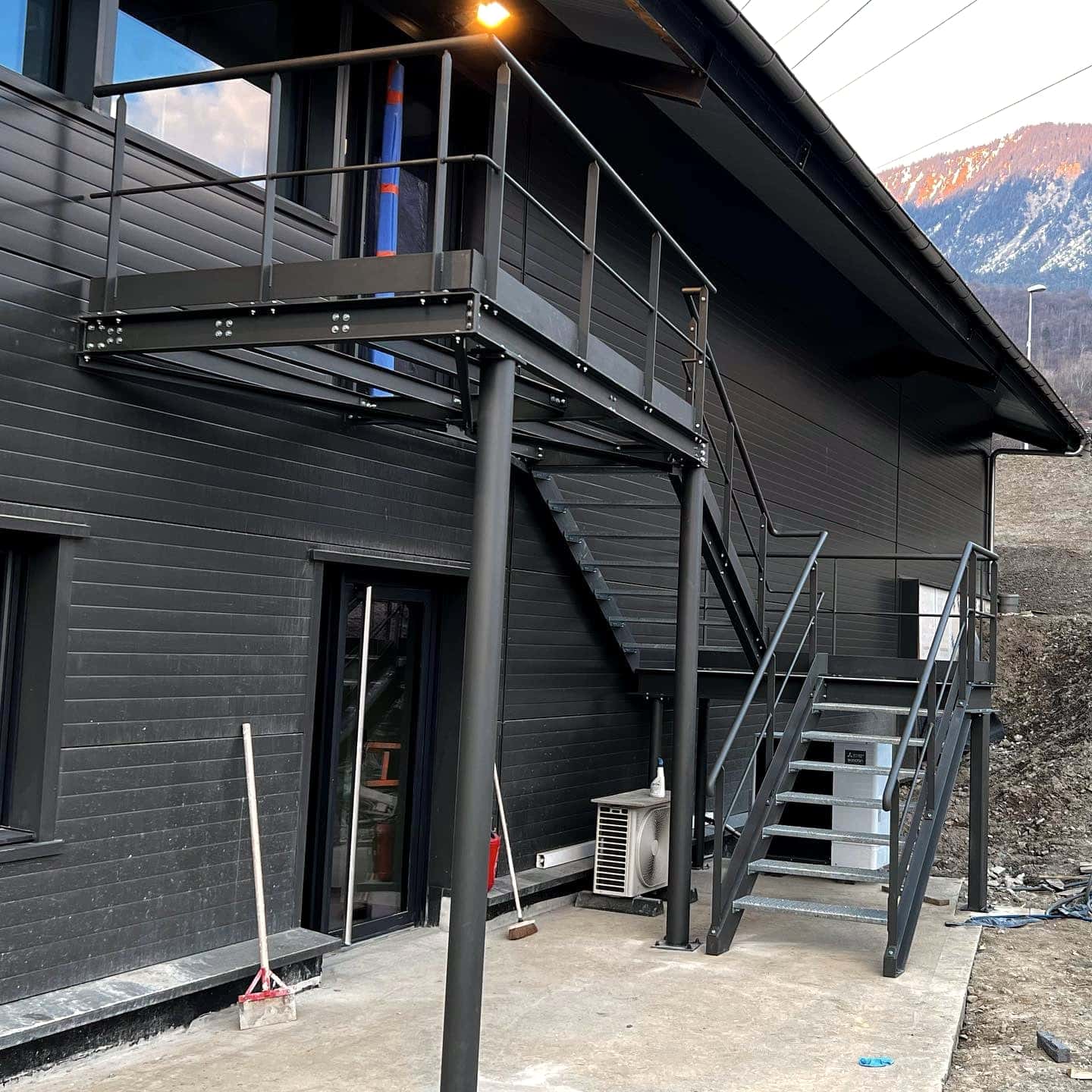Réalisation et pose d’un escalier et sa terrasse, l’ensemble thermolaqué à la teinte du bâtiment.